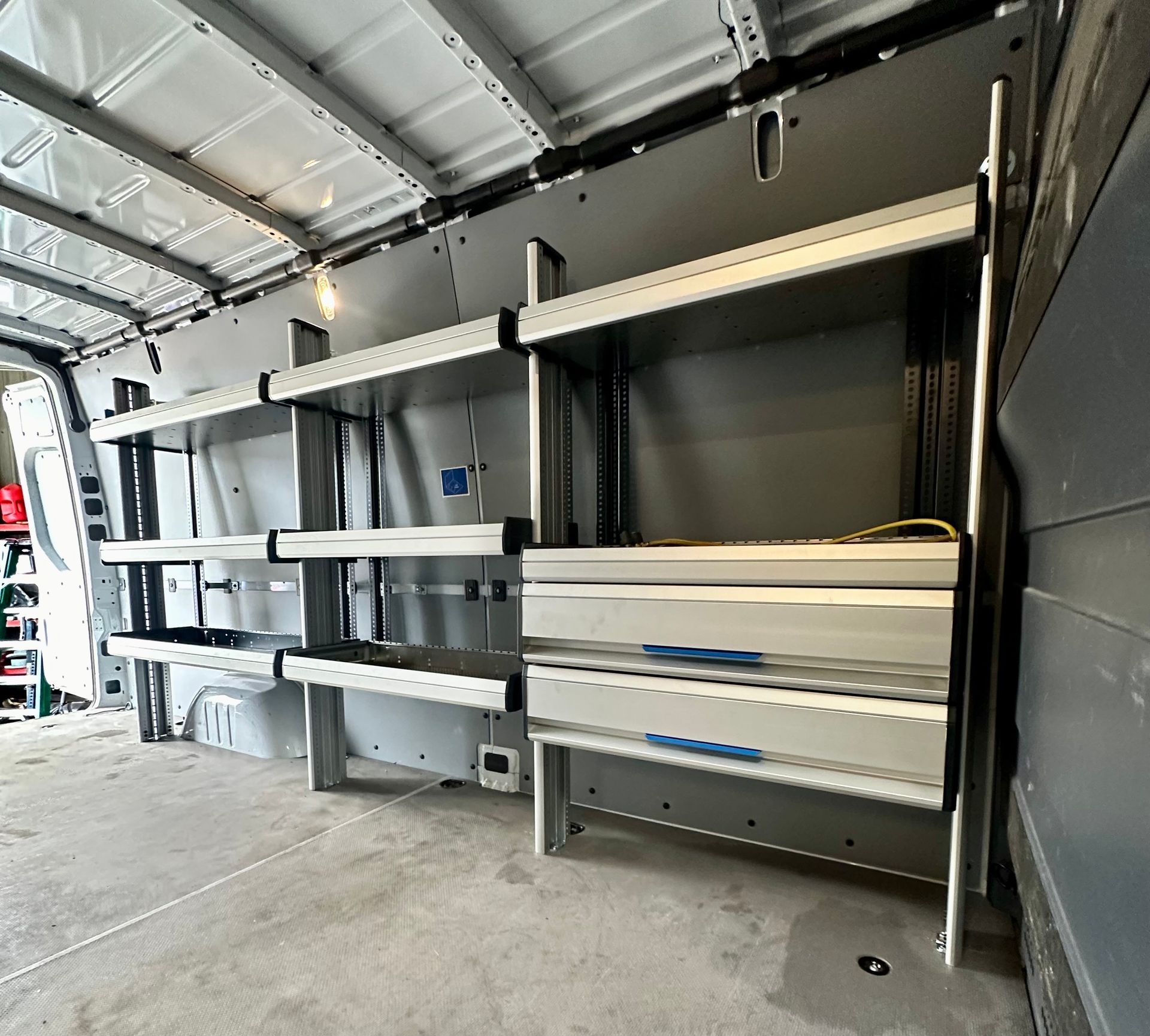 Blue flatbed truck with front damage, on a road.