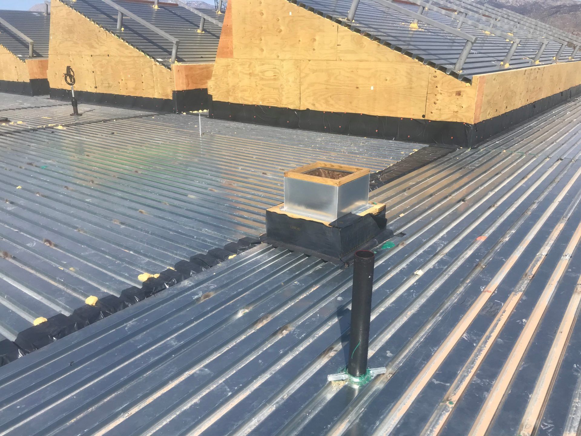 Metal roof with chimney and skylights under construction.