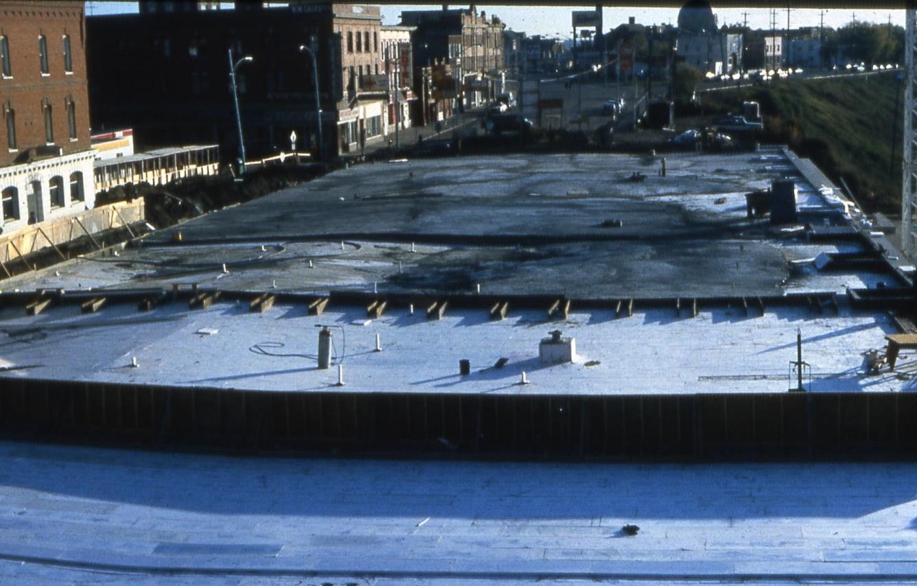 Construction site with concrete base and surrounding city buildings.