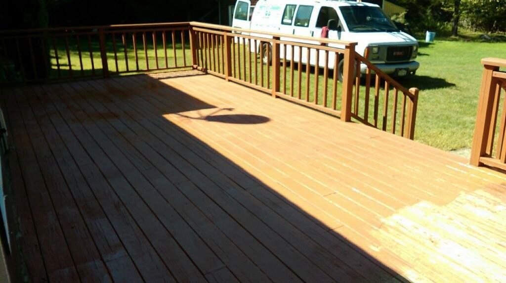 A white van is parked on a wooden deck