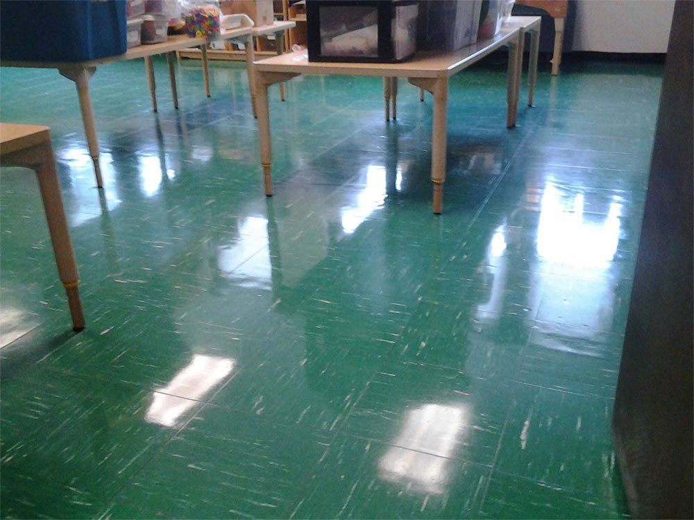 A green floor with tables and chairs on it