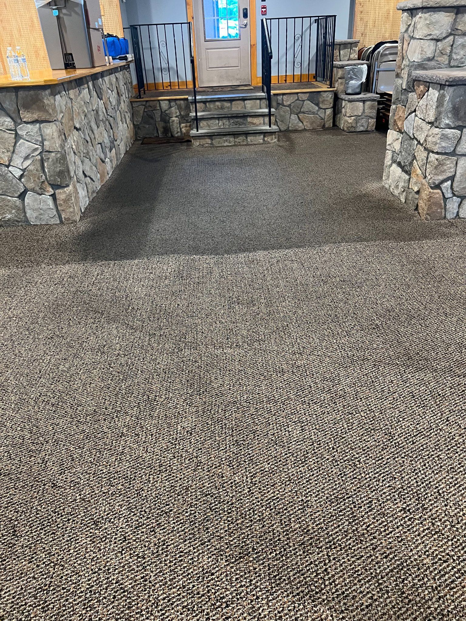 A gravel driveway leading to a stone wall and stairs.