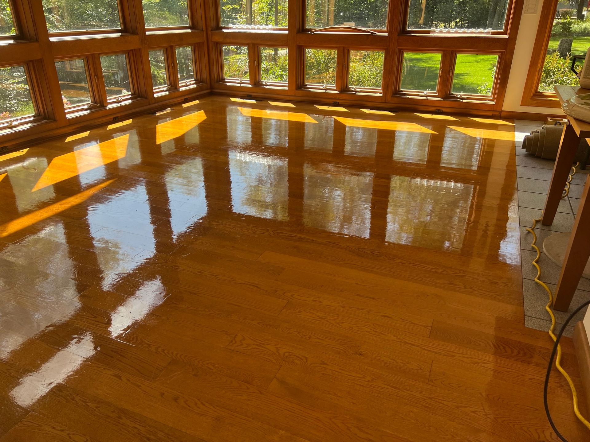 A room with a lot of windows and a wooden floor