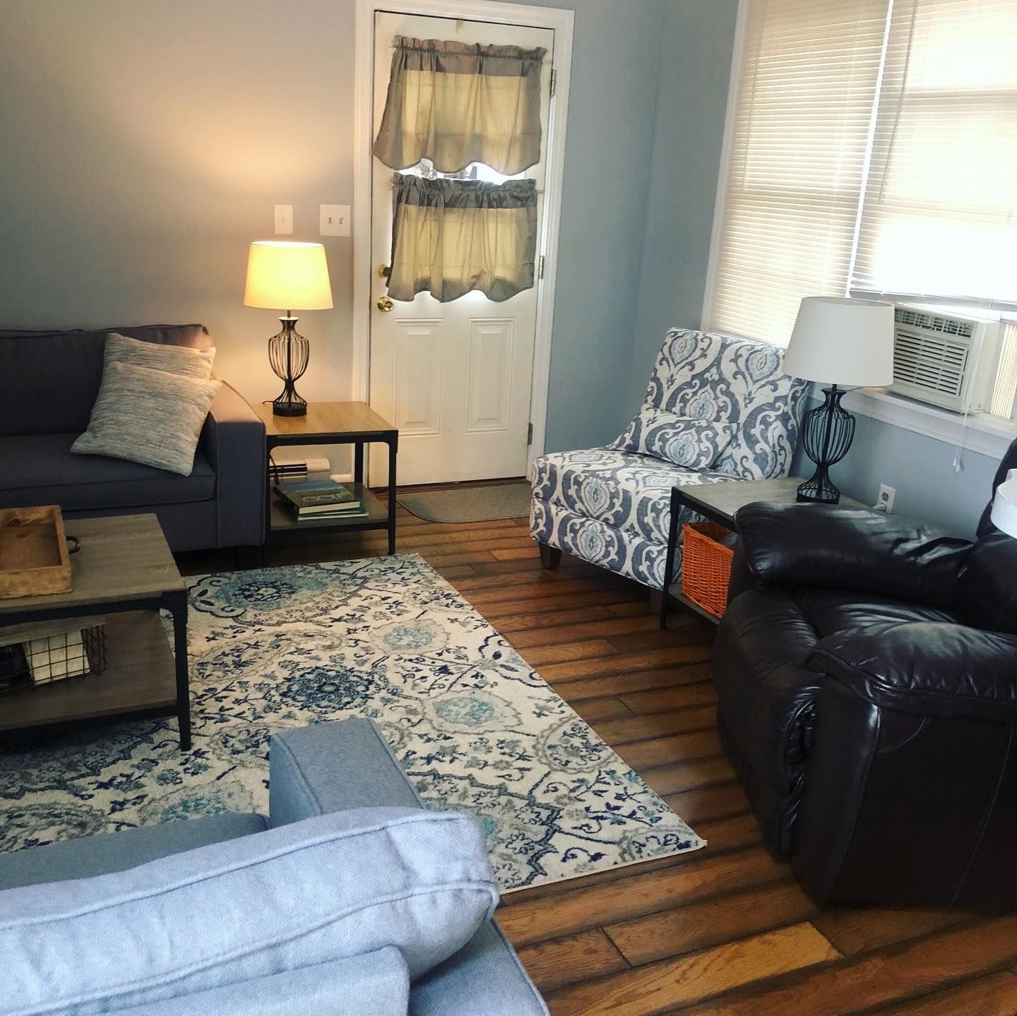 A living room with a couch , chair , coffee table and rug