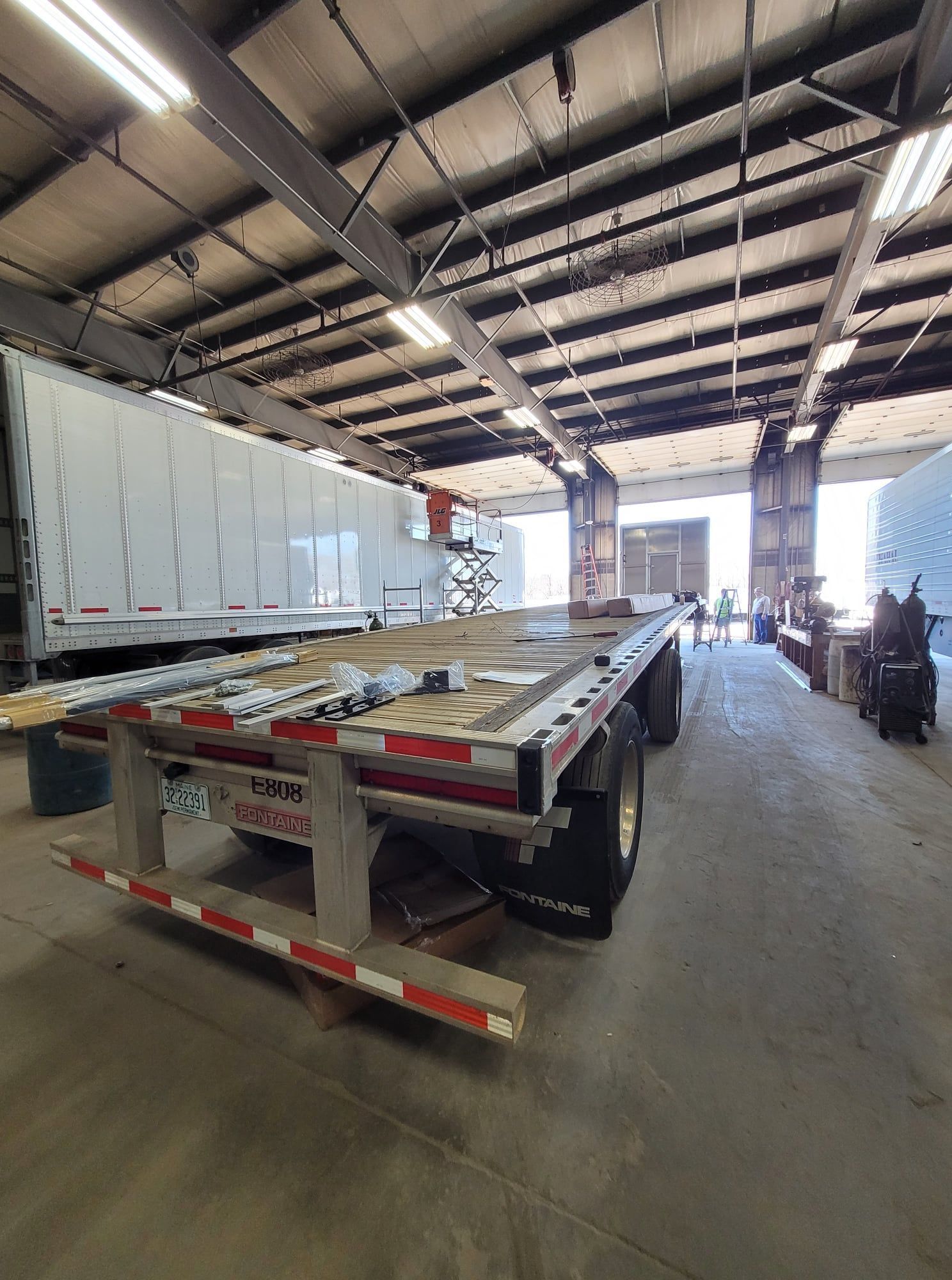 Truck trailer inside a warehouse loading area with a covered roof and open doorway