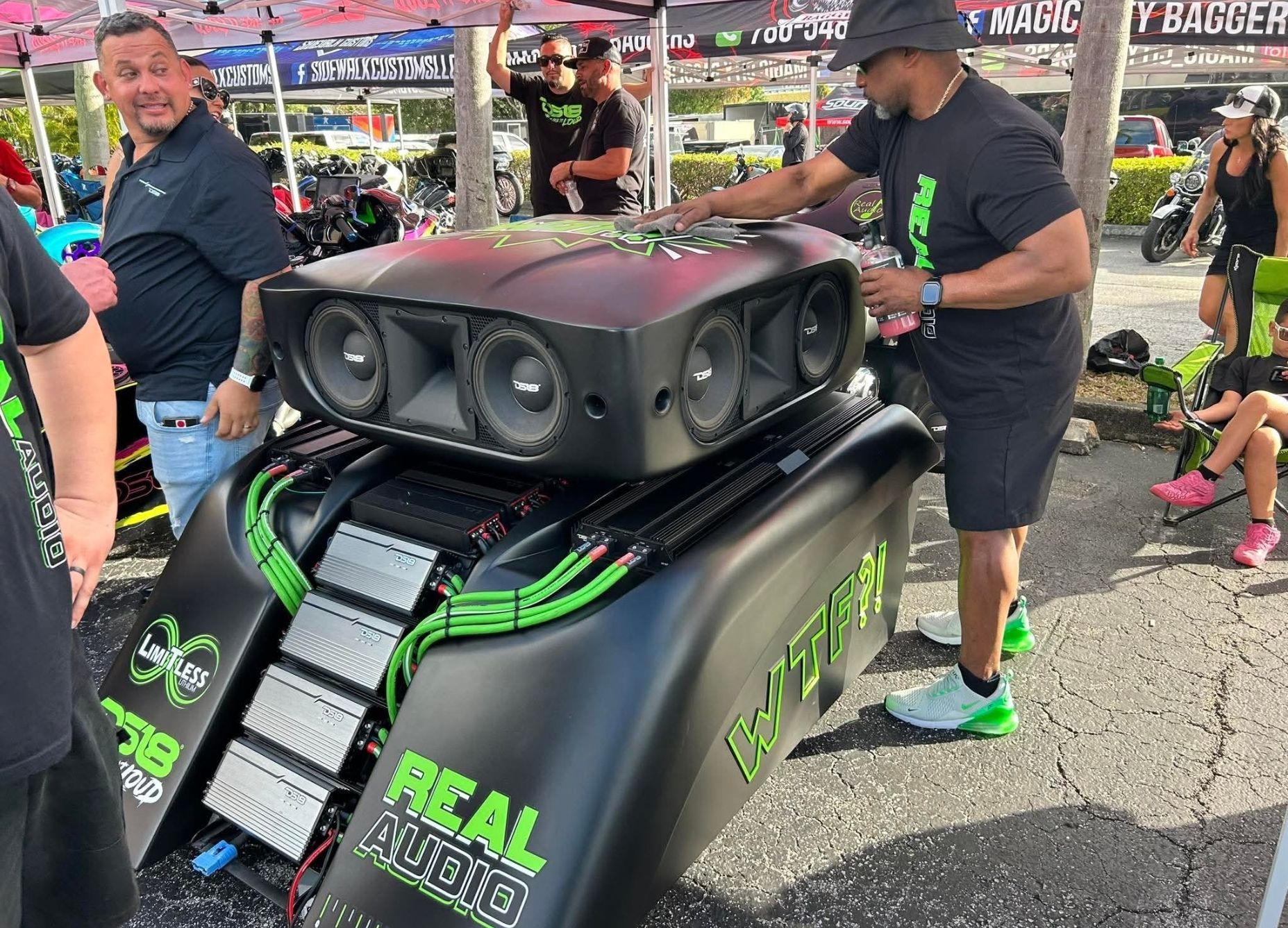 A group of men are standing around a large speaker.