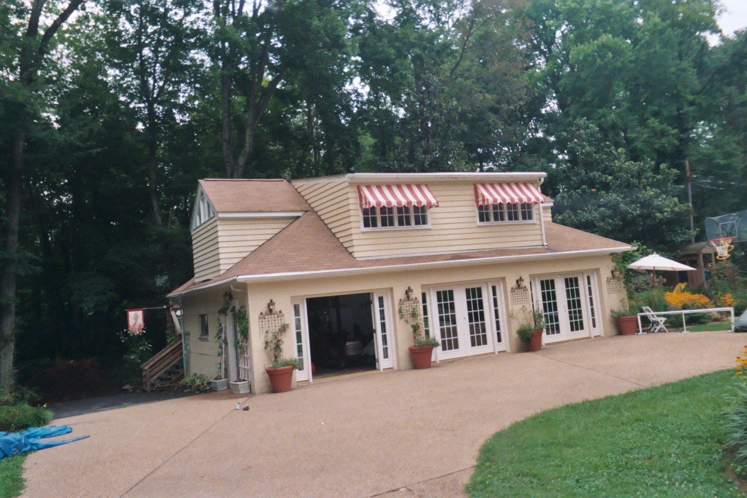 A brick building with a canopy that says The Arbors Apartments