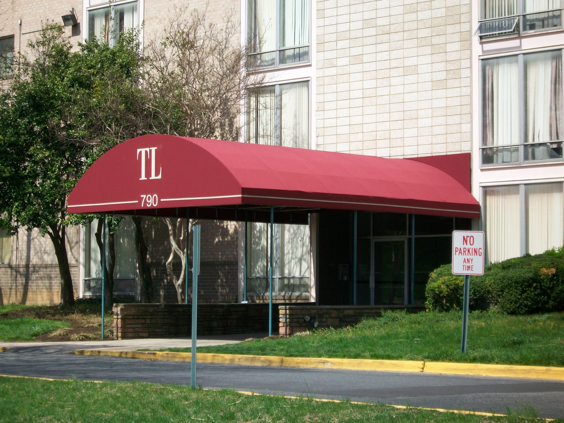 A brick building with a red awning over the entrance