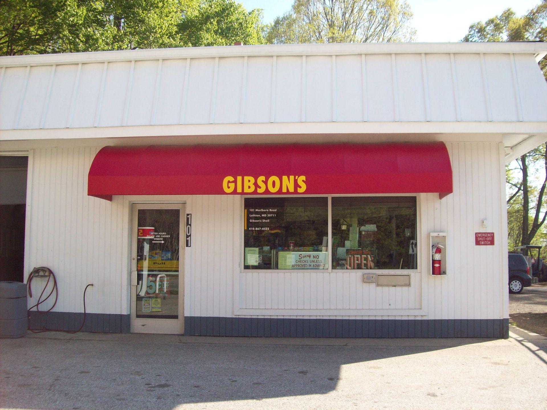 A white building with a red awning that says gibsons