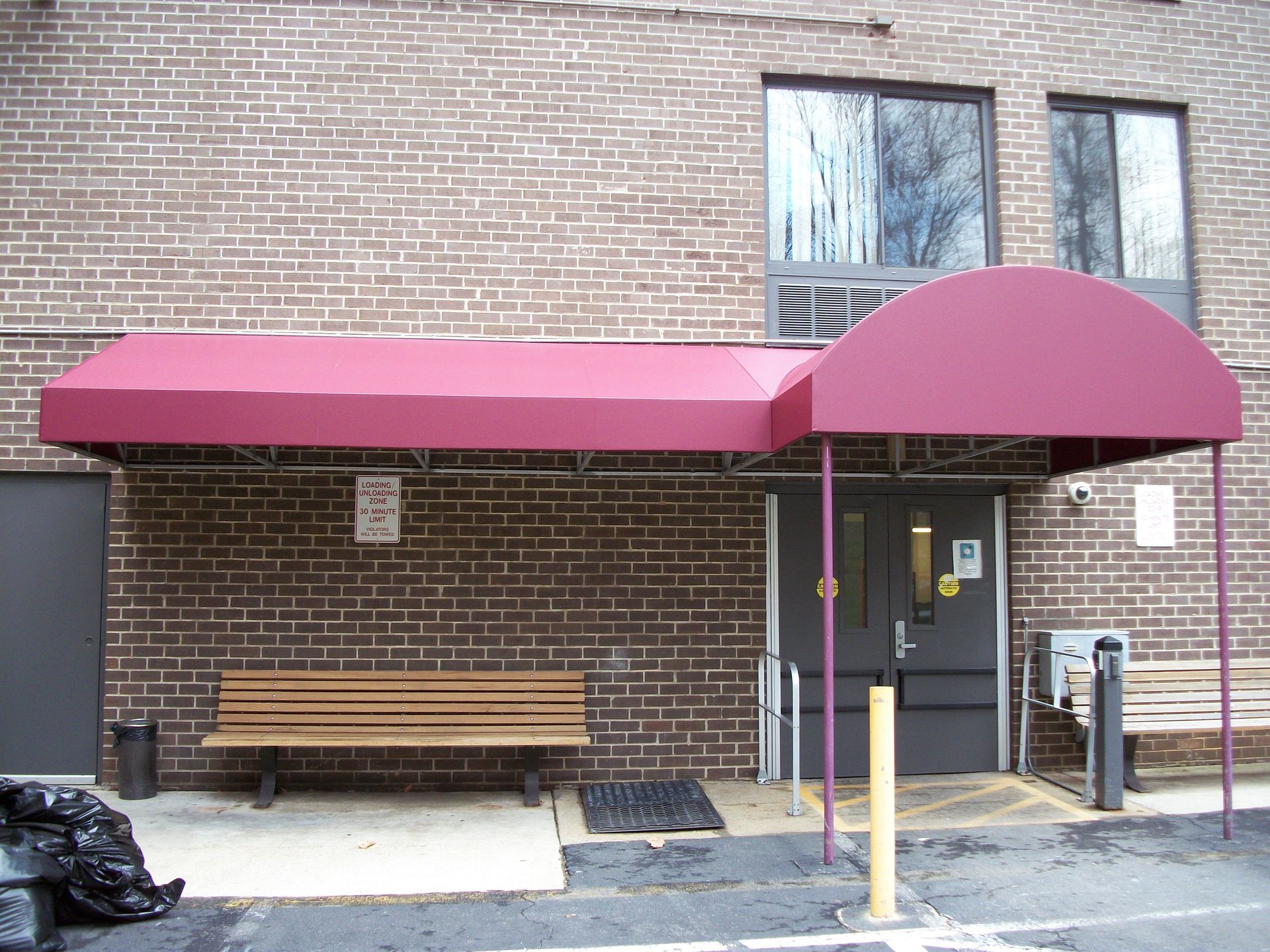 A brick building with a red awning over the entrance