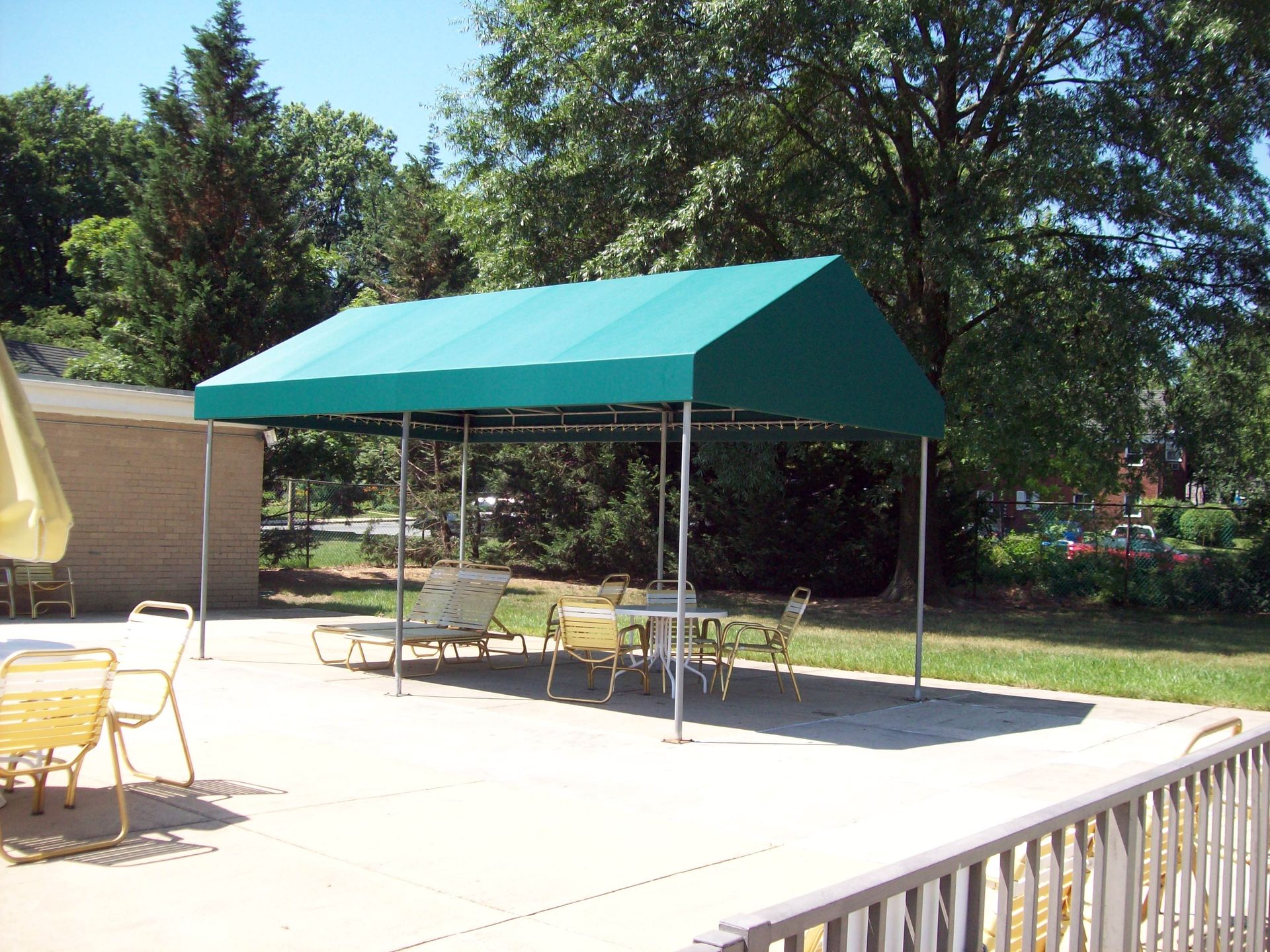 A green canopy with tables and chairs underneath it
