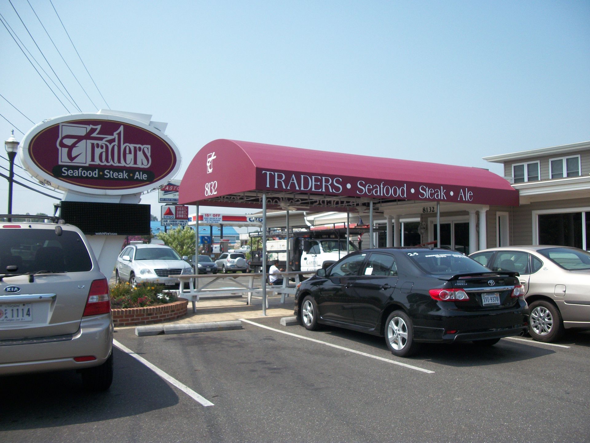 Several cars are parked in front of traders restaurant