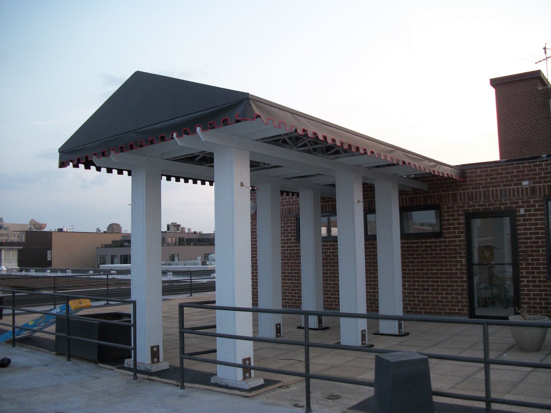 A brick building with a roof that has a canopy over it