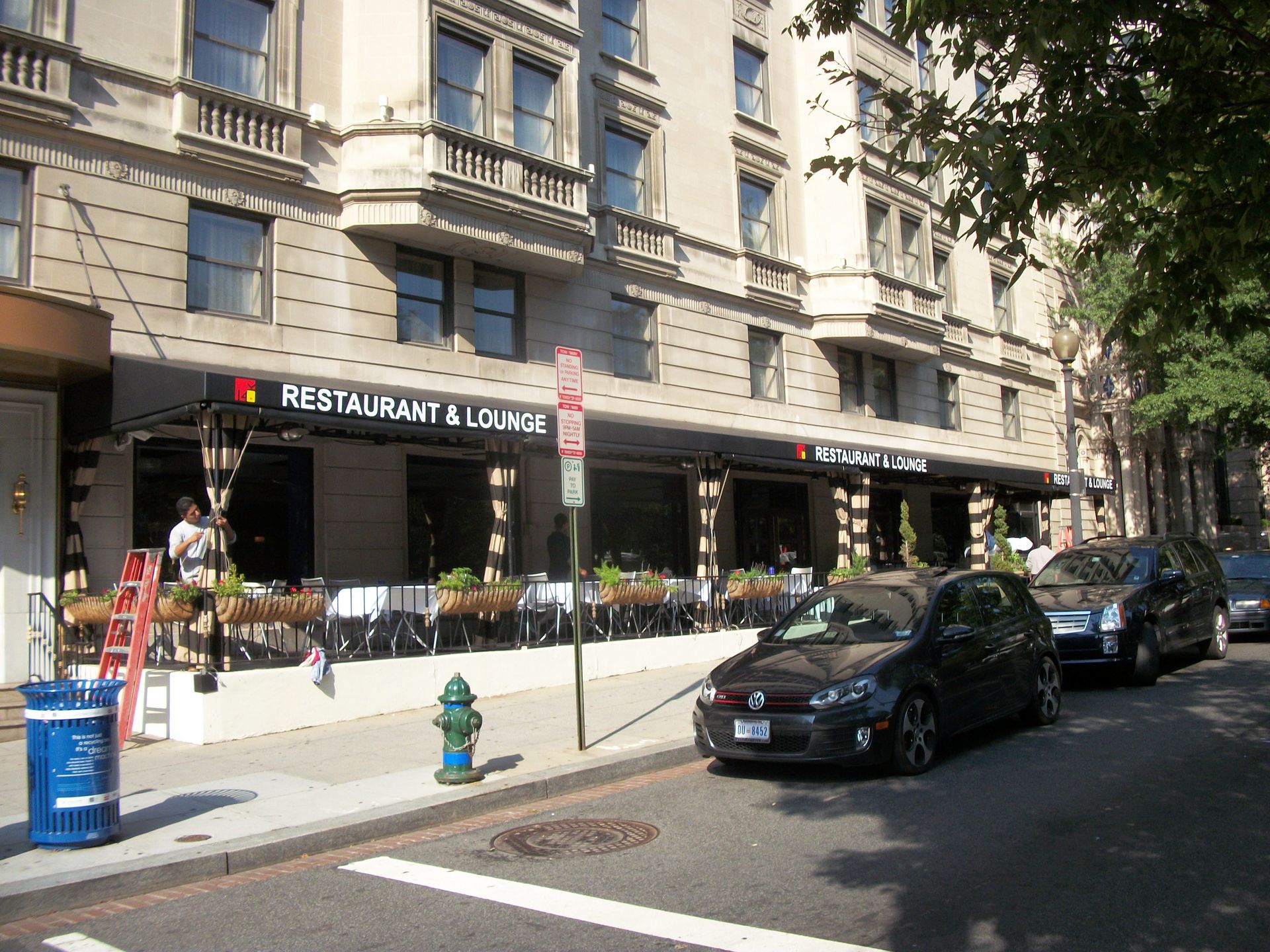 A row of cars are parked in front of a restaurant