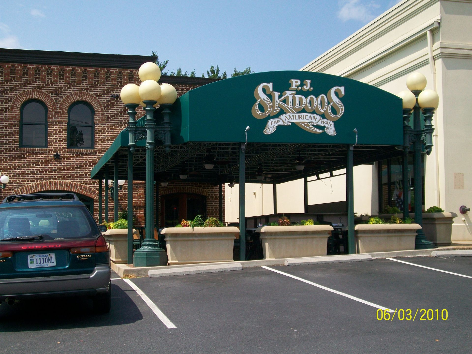 A car is parked in front of a skidogs restaurant