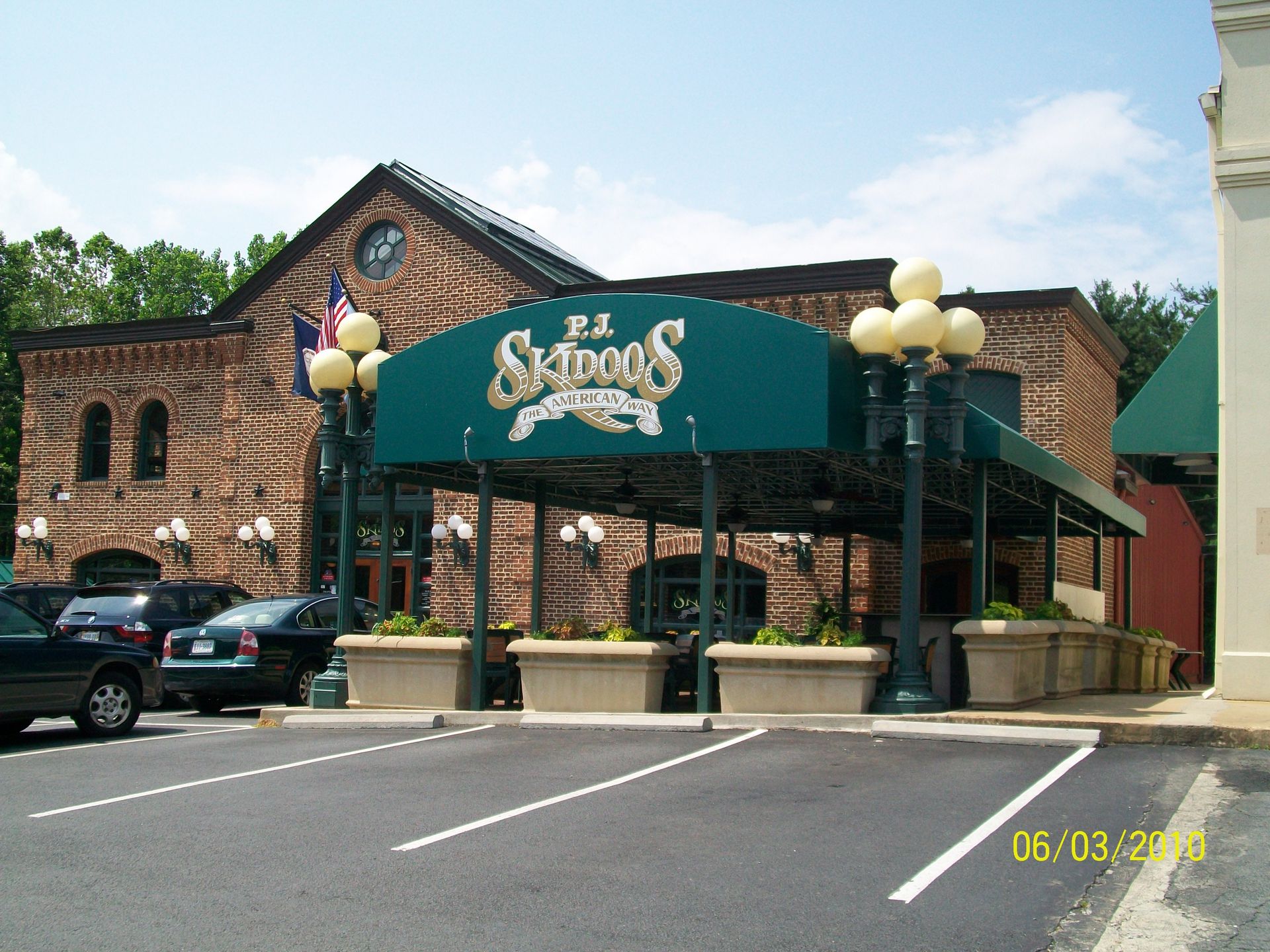 A brick building with a green awning that says Skidogs