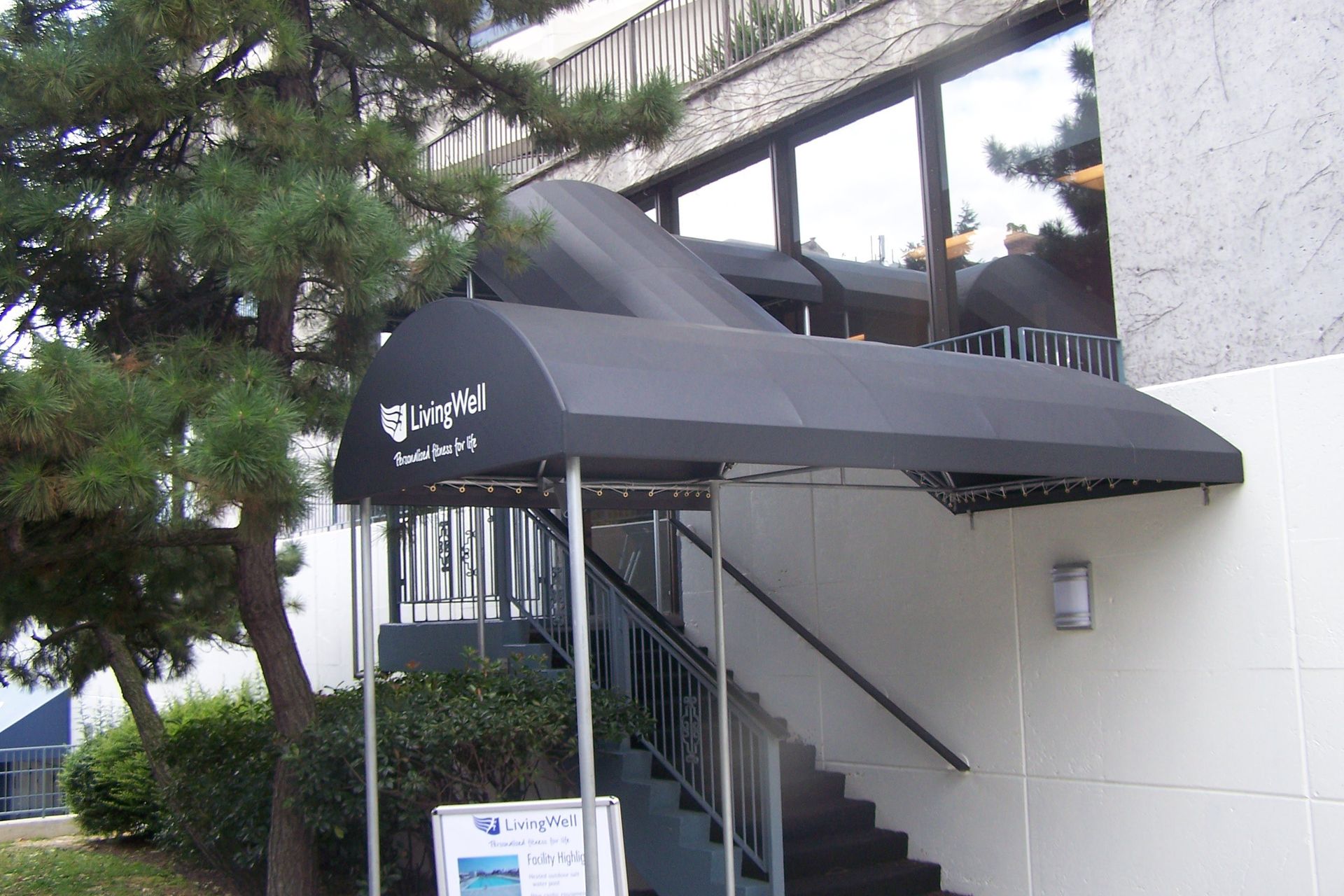 A building with stairs and a black awning that says bluefin