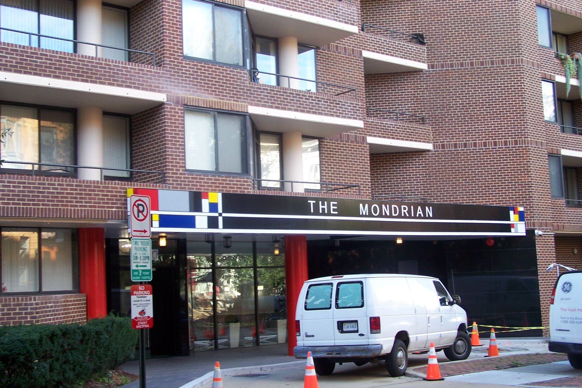 A white van is parked in front of a building that says the monorian