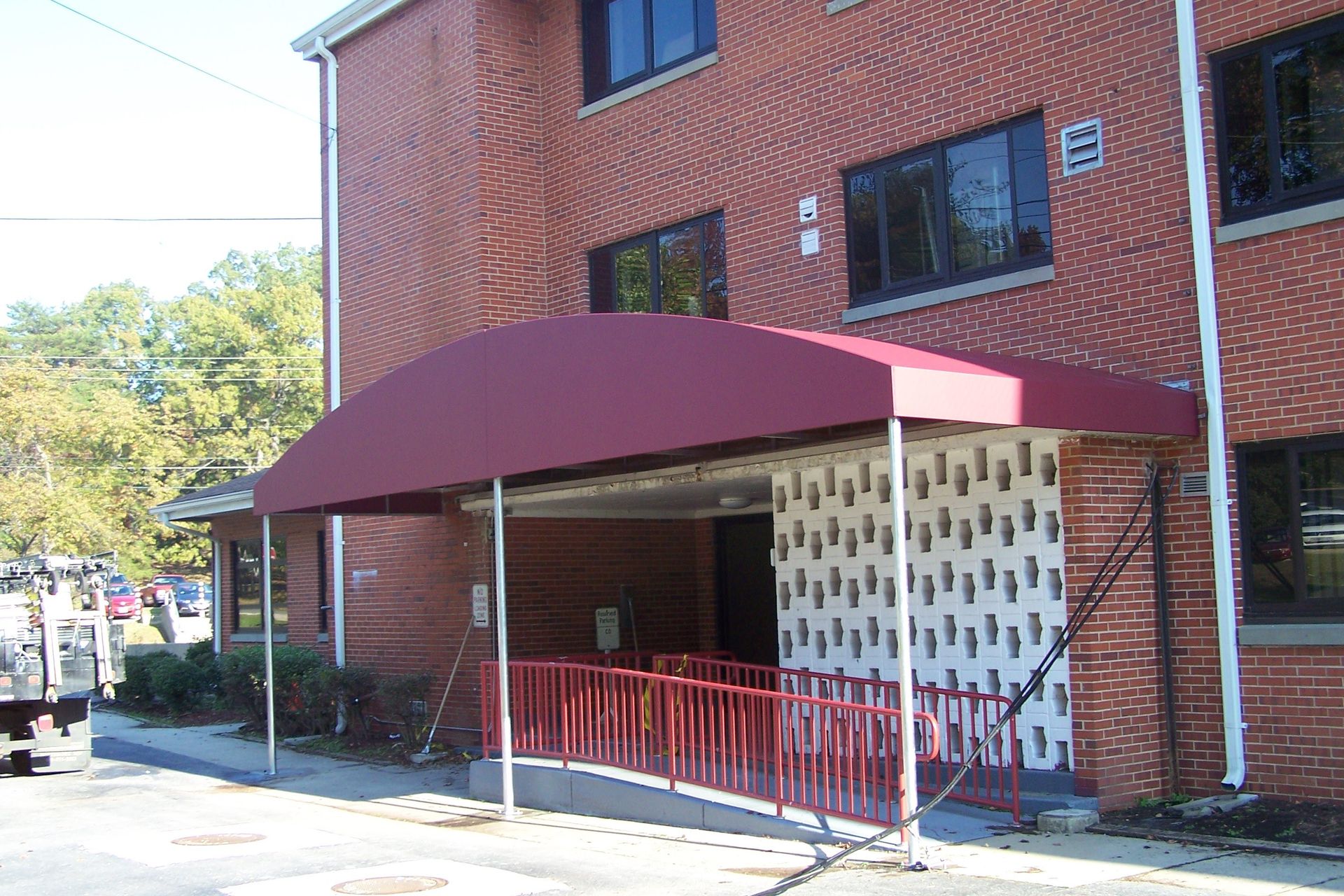 A brick building with a red awning over the entrance