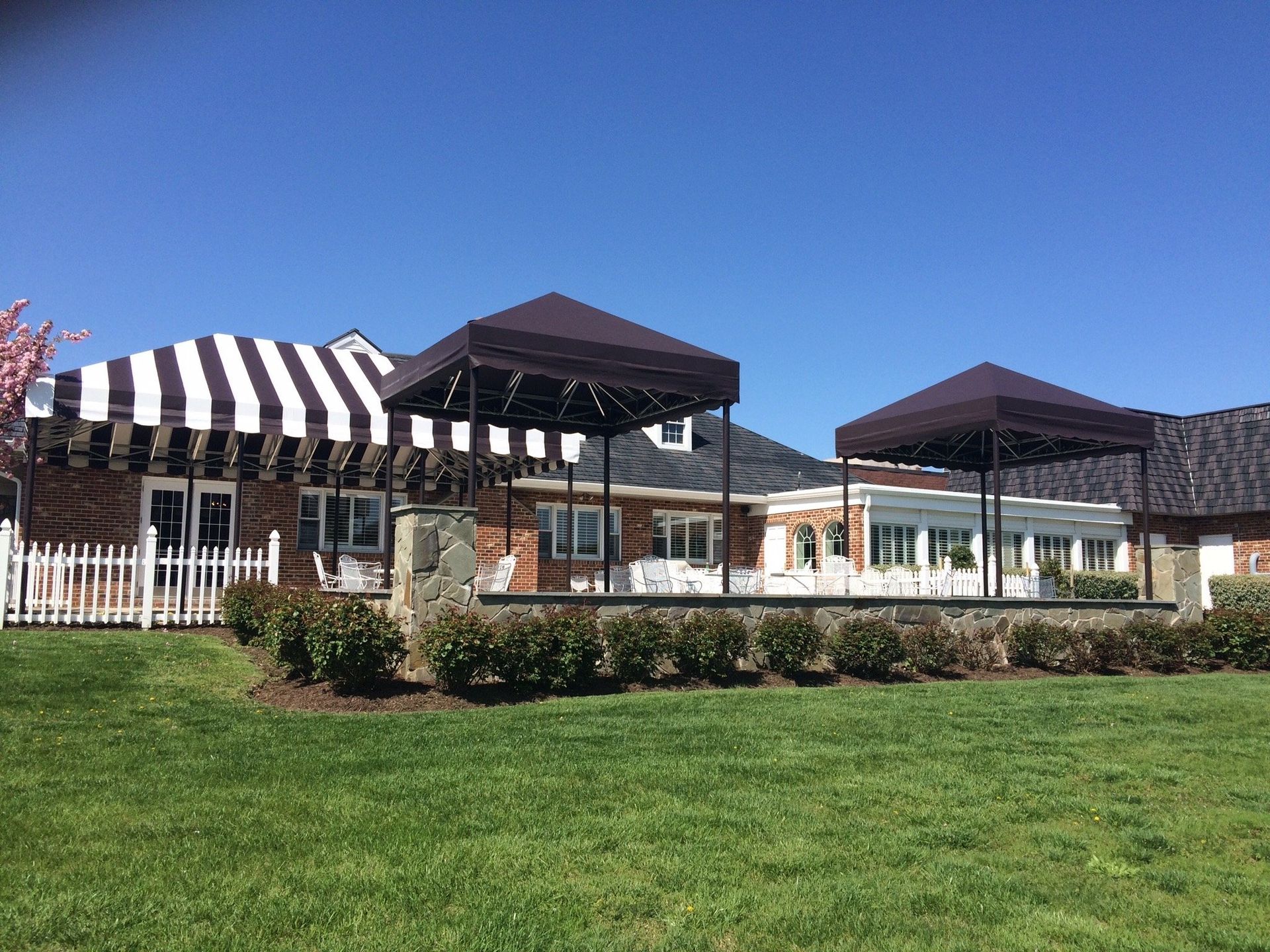 A house with a striped awning on the side of it.