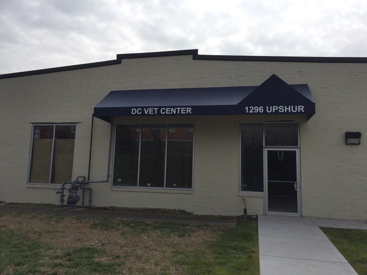 A white building with a blue awning that says dc vet center
