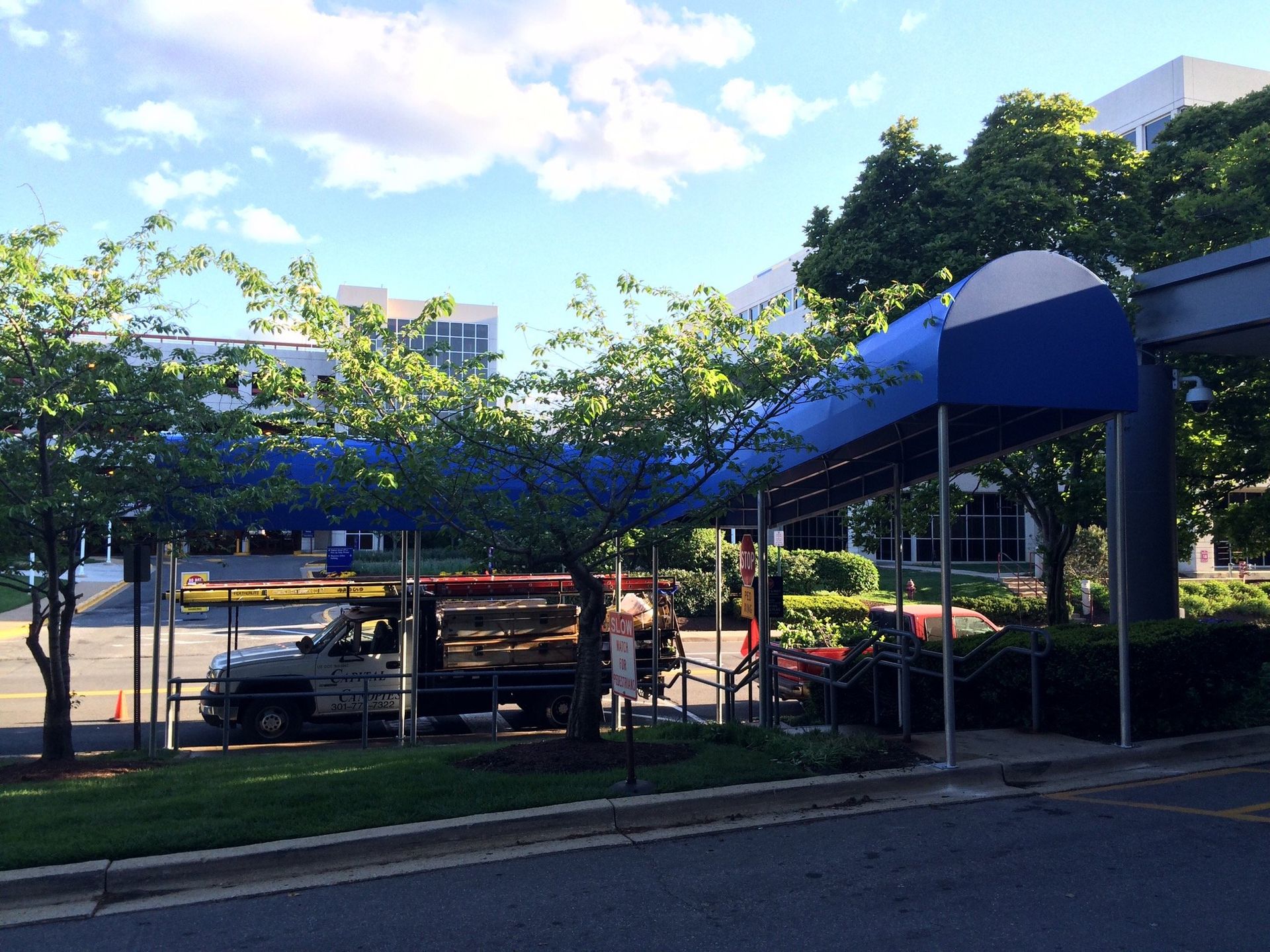 A truck is parked under a blue awning in front of a building