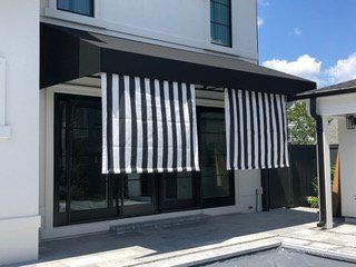 A black and white striped awning is on the side of a house