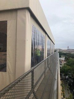 A balcony with a fence and a canopy on the side of a building