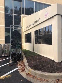 A large building with a lot of windows is sitting next to a parking lot.