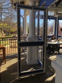 A woman is sitting at a table in a restaurant behind a glass door