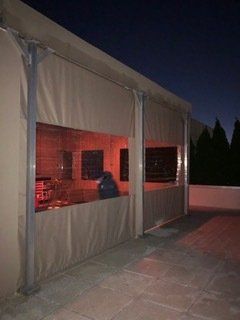 A large tent with a grill inside of it is lit up at night