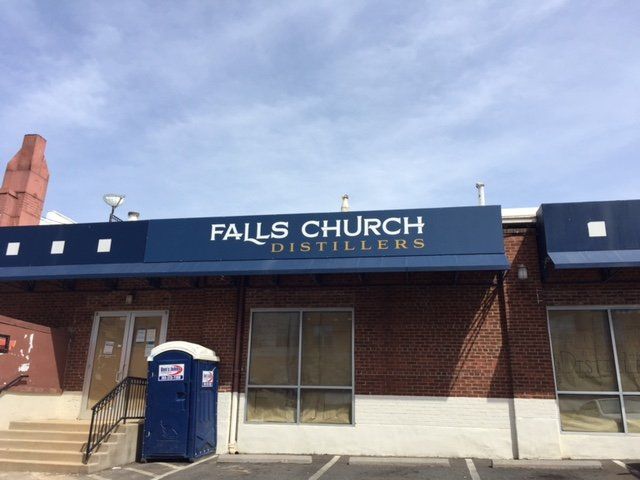 A brick building with a canopy that says The Arbors Apartments