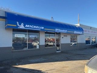 A michelin tire shop with a blue awning over the front door.