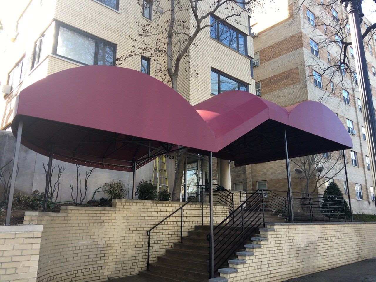 A building with a red awning over the entrance and stairs