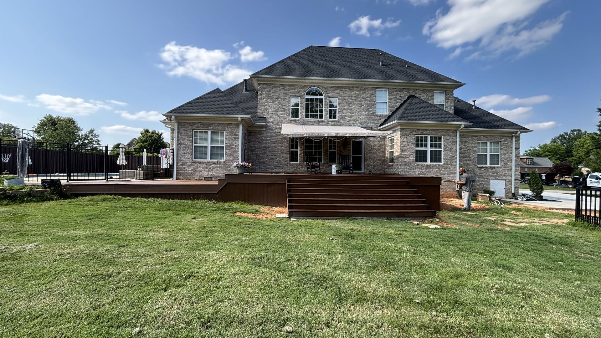 A large brick house with a large lawn in front of it.