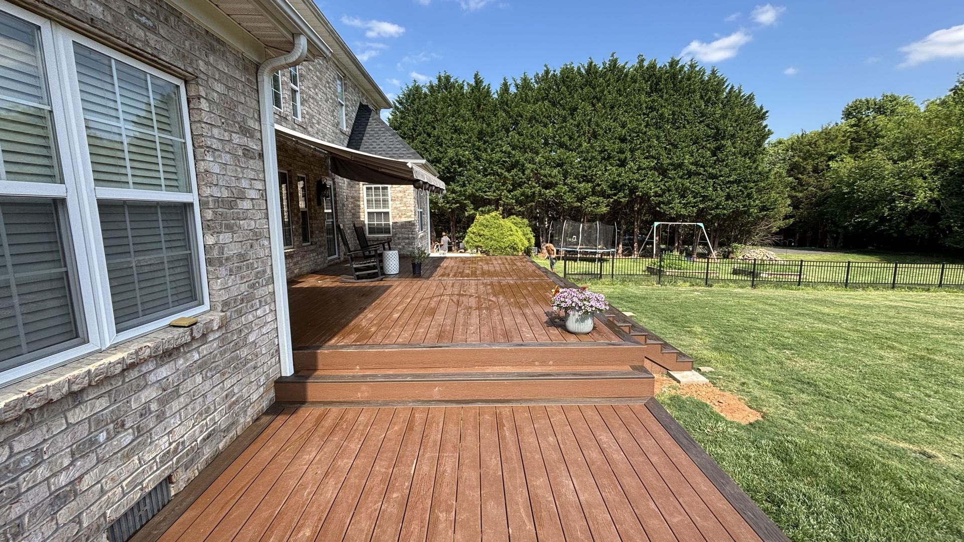 A brick house with a wooden deck in front of it.