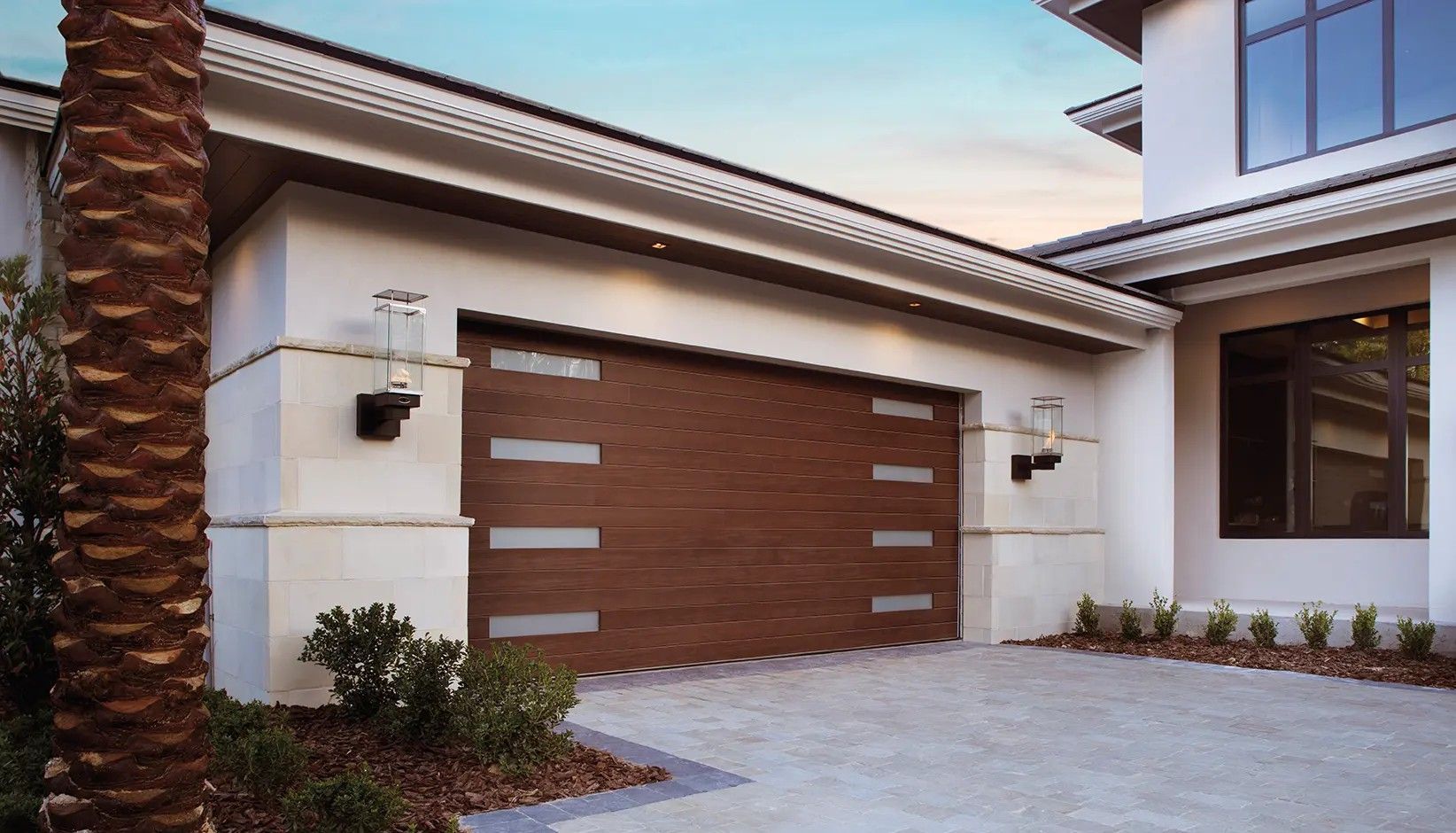 A modern home exterior featuring a horizontal wood-grain garage door with thin, frosted rectangular windows.
