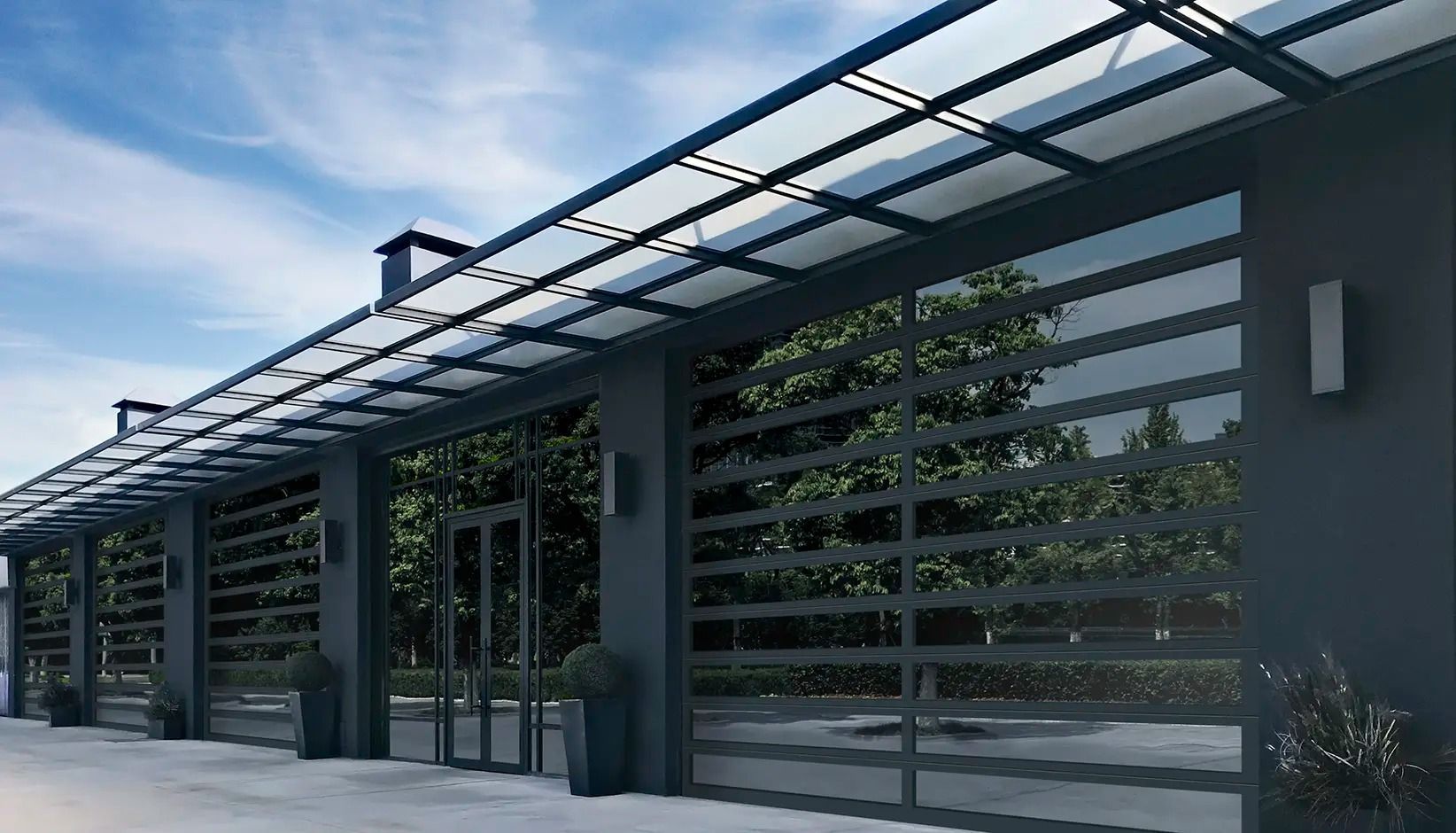 Modern house frontage with a metal pergola, horizontal slat fence, and potted plants along the driveway