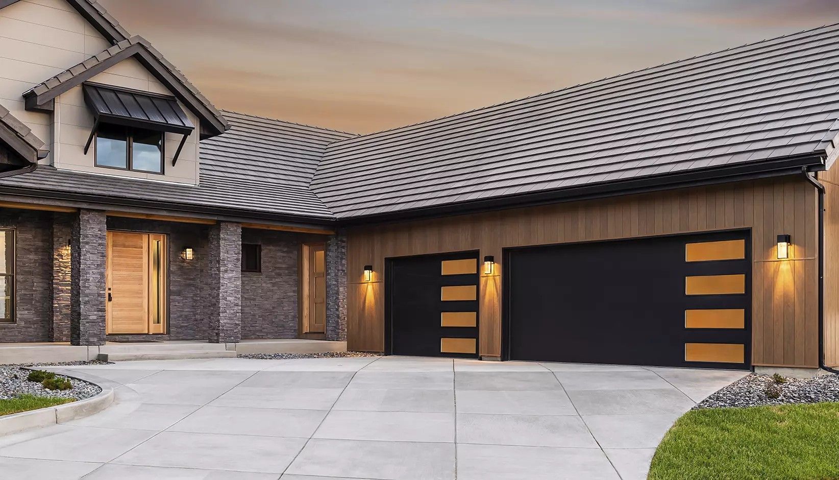 A modern house with a stone facade, wood siding, and two black garage doors with horizontal wood-paneled windows.