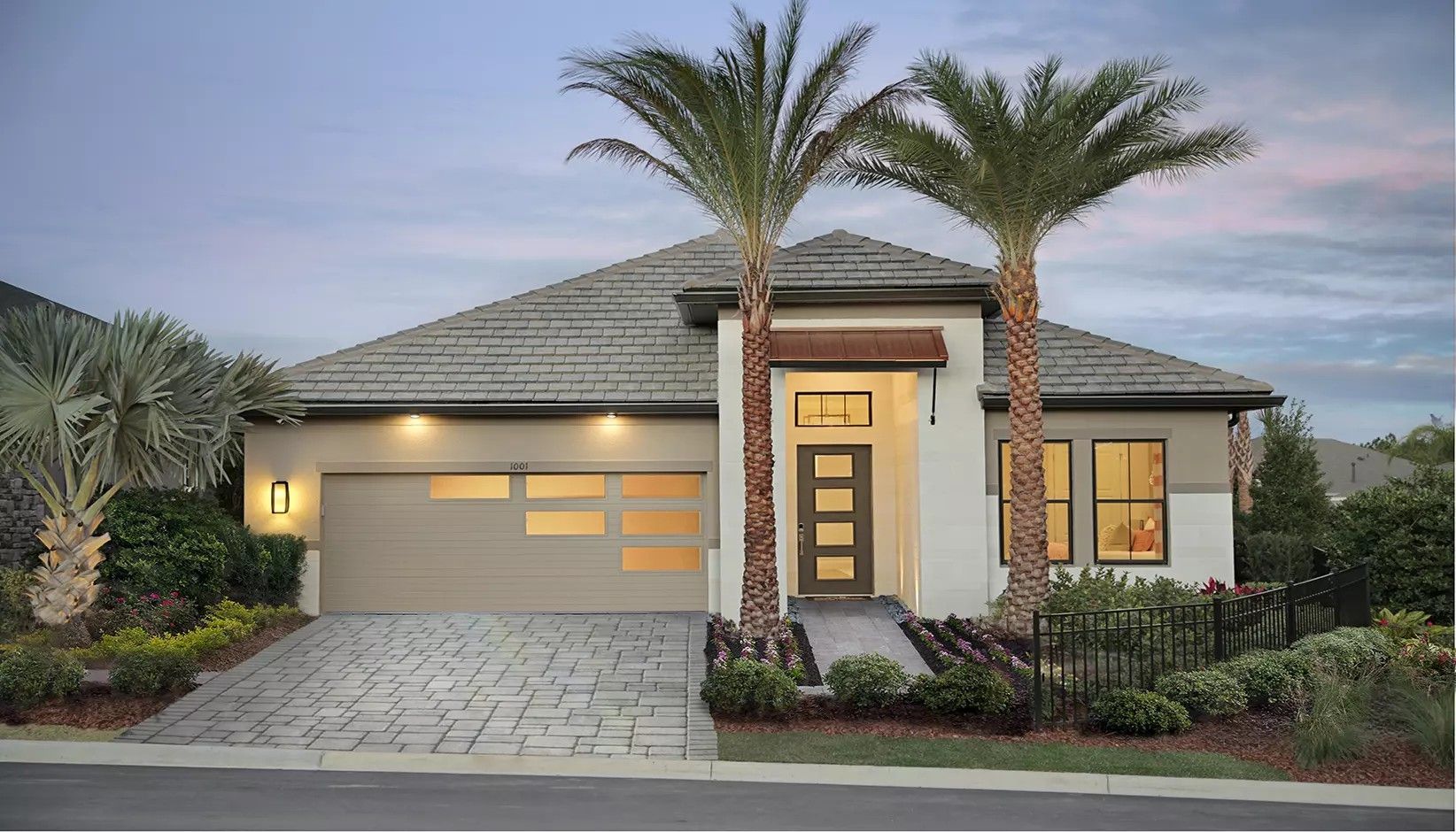 Modern one-story suburban home with a tan stucco exterior, tile roof, contemporary garage door, and two tall palm trees.