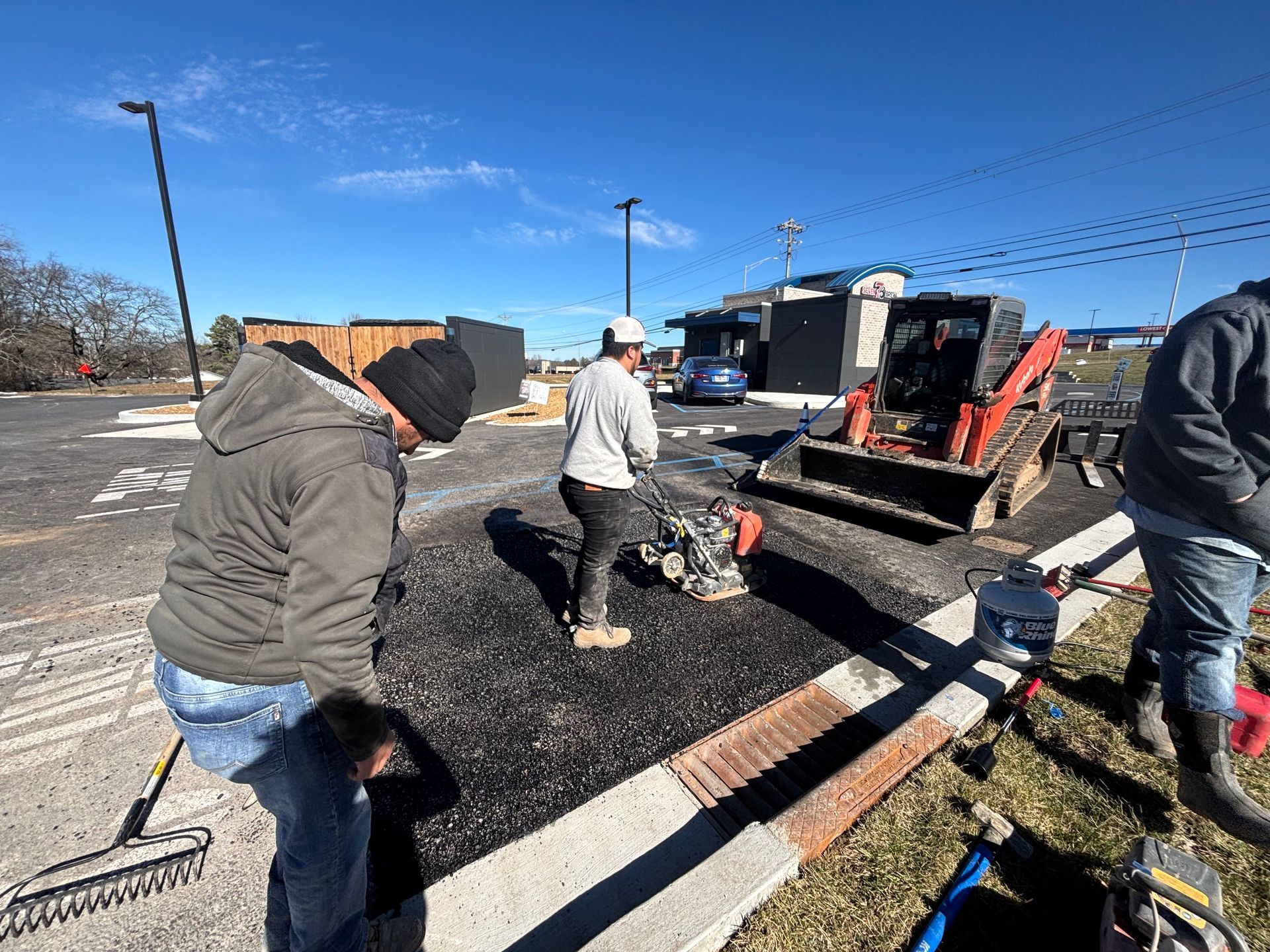 A group of construction workers are working on a road.