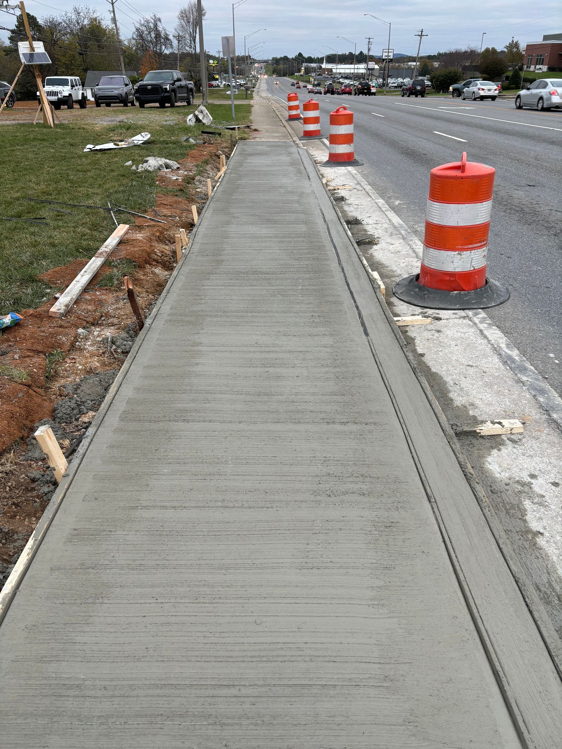 A sidewalk is being built on the side of a road.