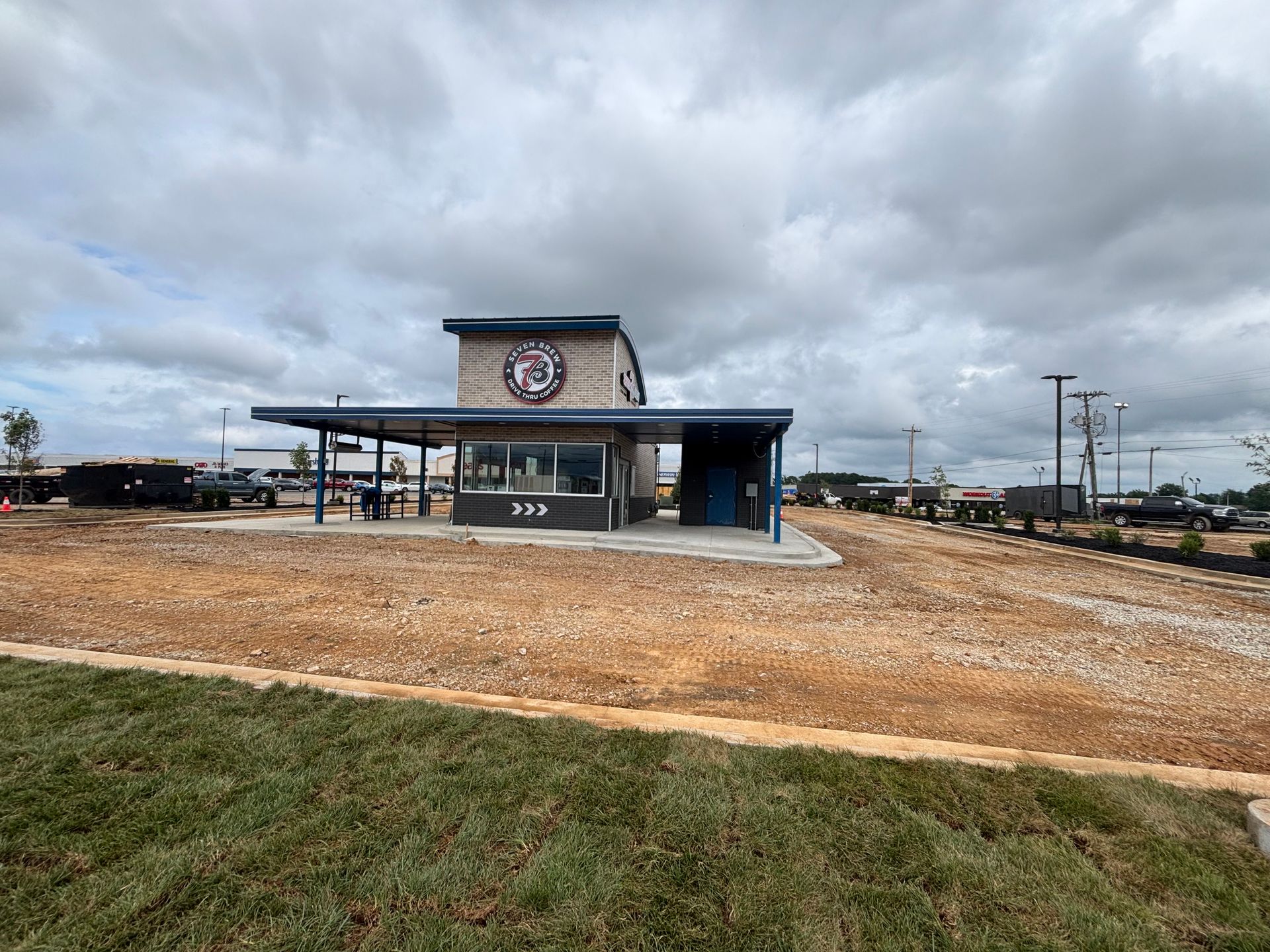 A building is sitting in the middle of a dirt field.