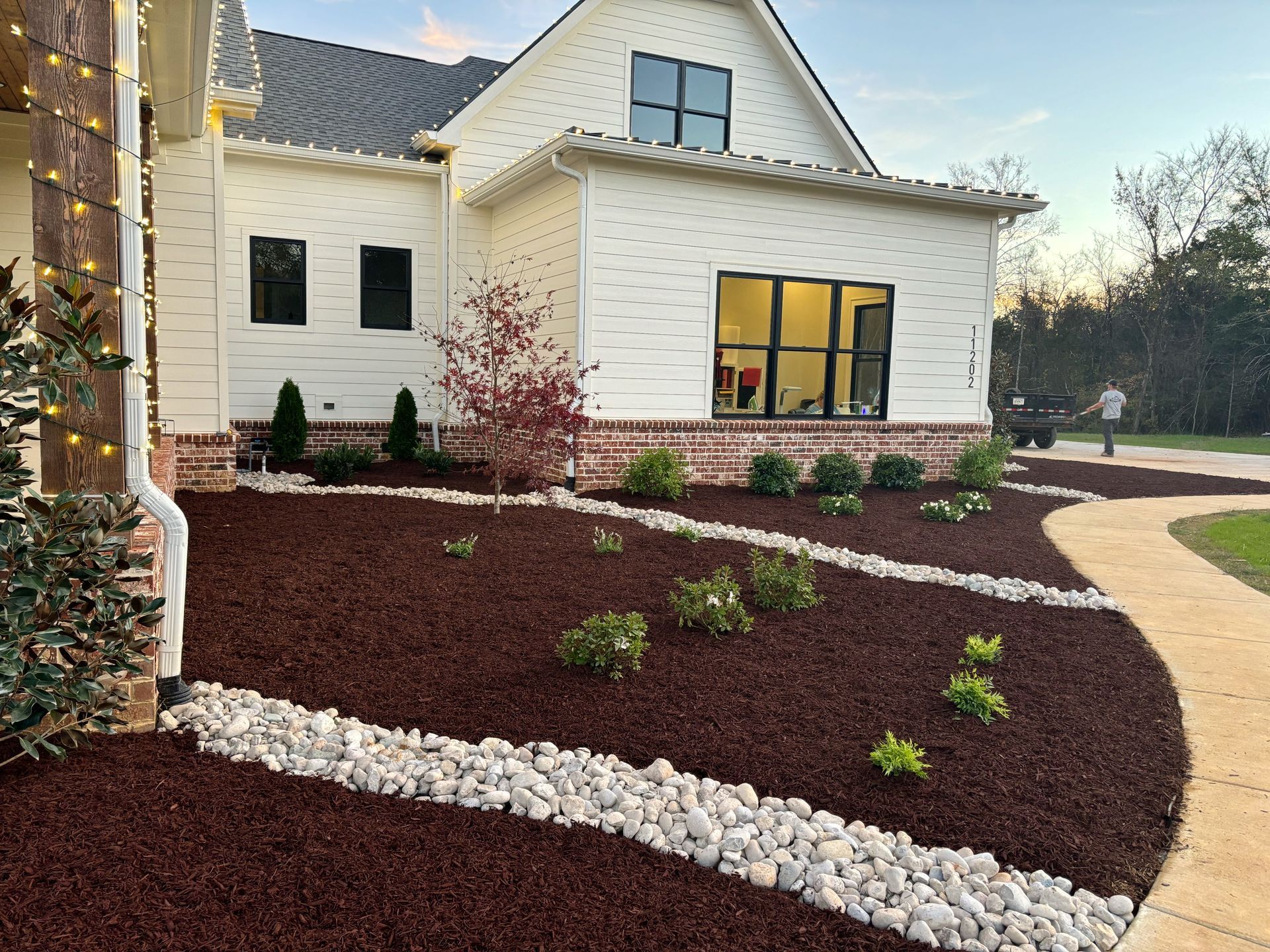 A white house with a lush green lawn and a walkway leading to it.