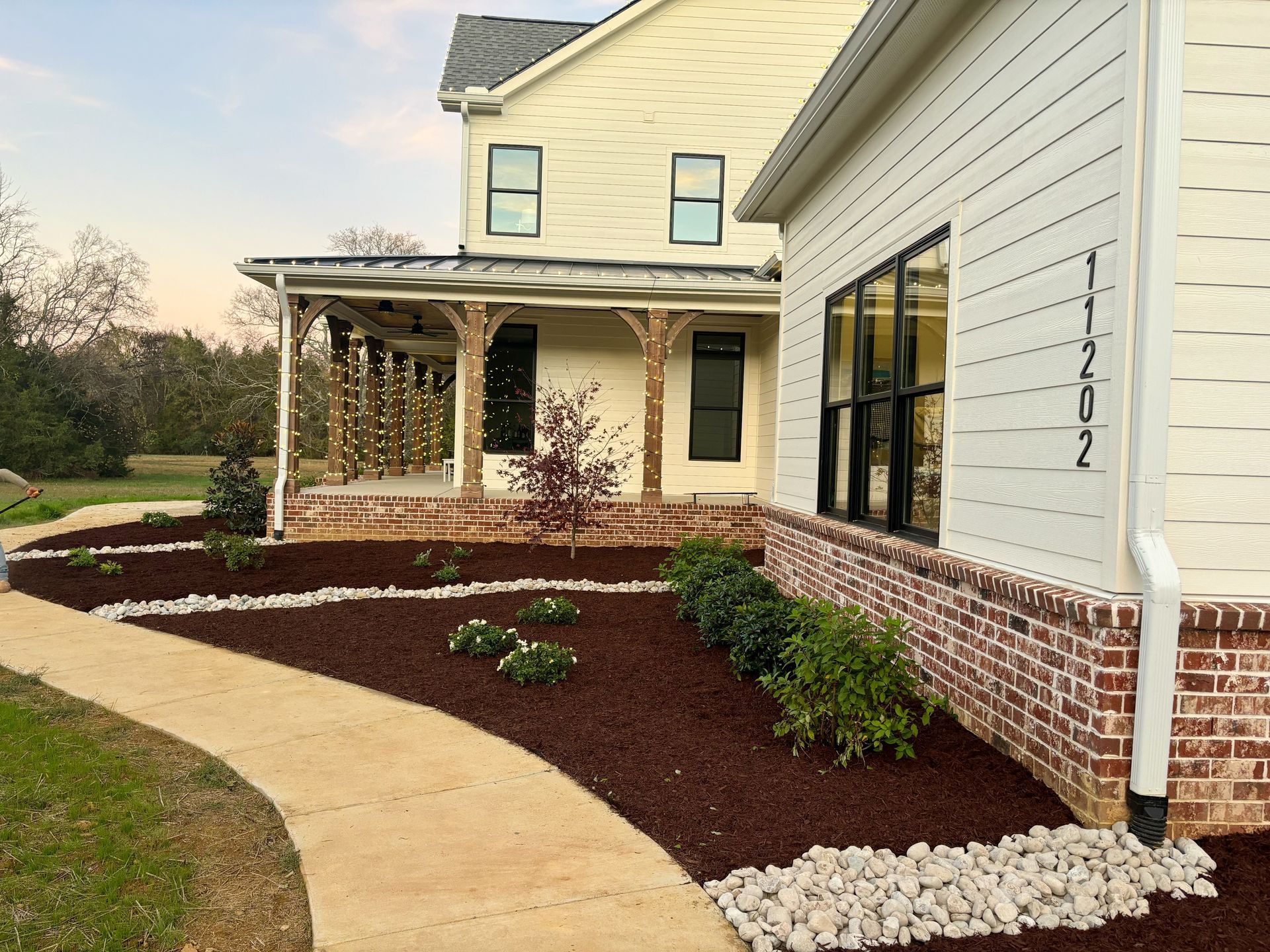 A white house with a brick walkway leading to it