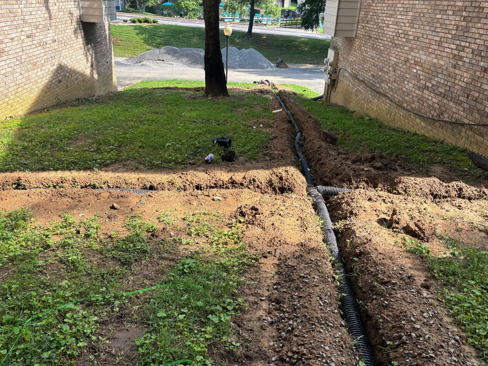 A drainage system is being installed in the backyard of a house.
