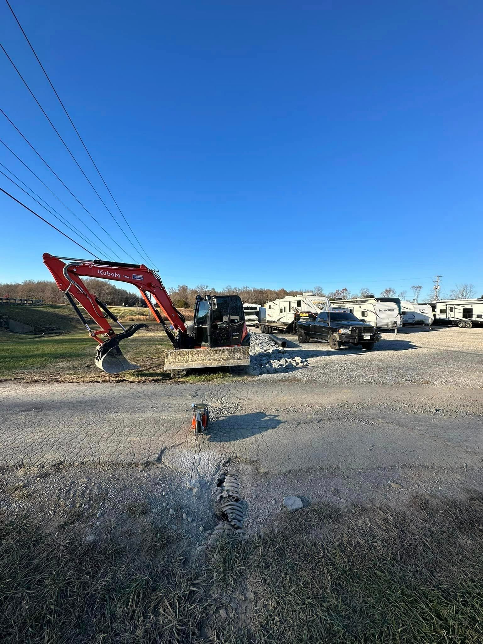 a red excavator is parked on the side of the road in a parking lot .