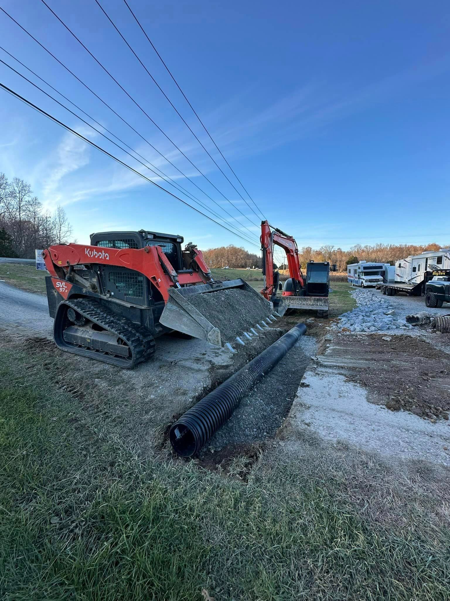 a bulldozer and an excavator are working on a construction site .