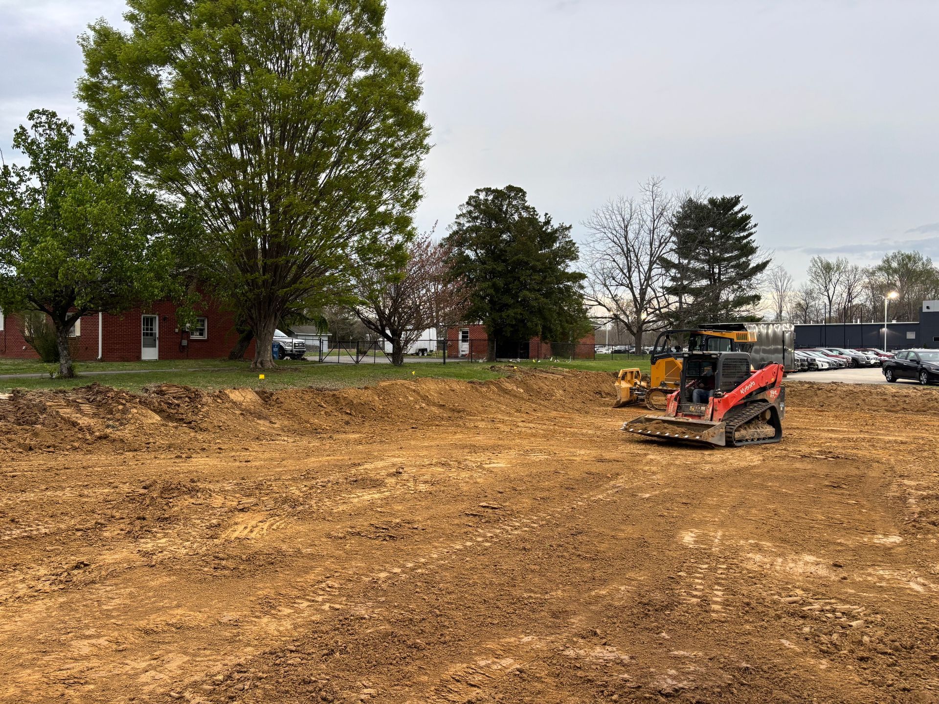 A bulldozer is moving dirt in a large dirt field.