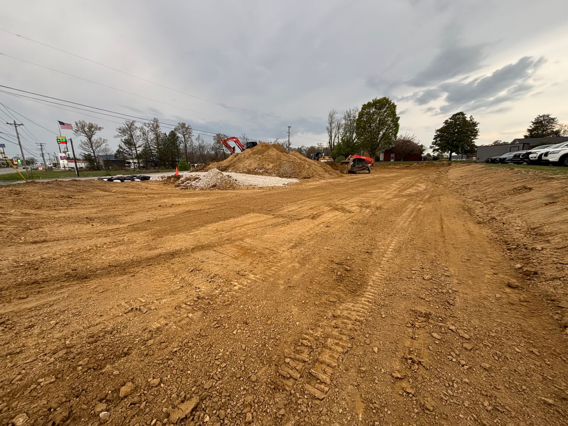 A large pile of dirt is sitting in the middle of a dirt road.